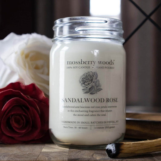 Sandalwood Rose country cottage candle in a mason jar with roses and a sandalwood incense stick on a wooden table