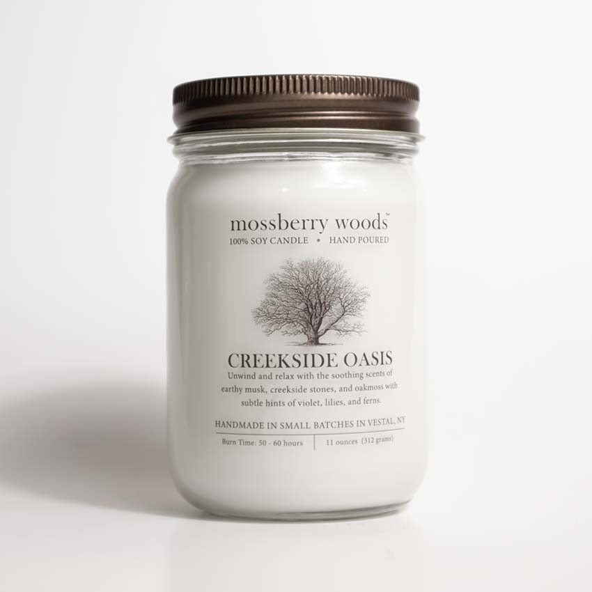 Creekside Oasis Country Cottage Candle in a mason jar and rustic brown lid on a white background