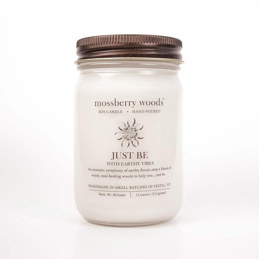 Just Be with Earthy Vibes scented candle in a mason jar with rustic brown lid on a white background