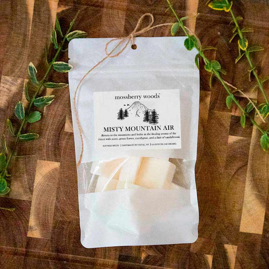 Misty Mountain Air wax melts in a white bag with a mountain scene 