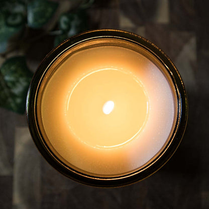 Top view of the lit amber glass candle showing the melt pool