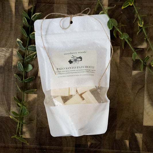 Palo Santo wax melts product on a wood table with greenery