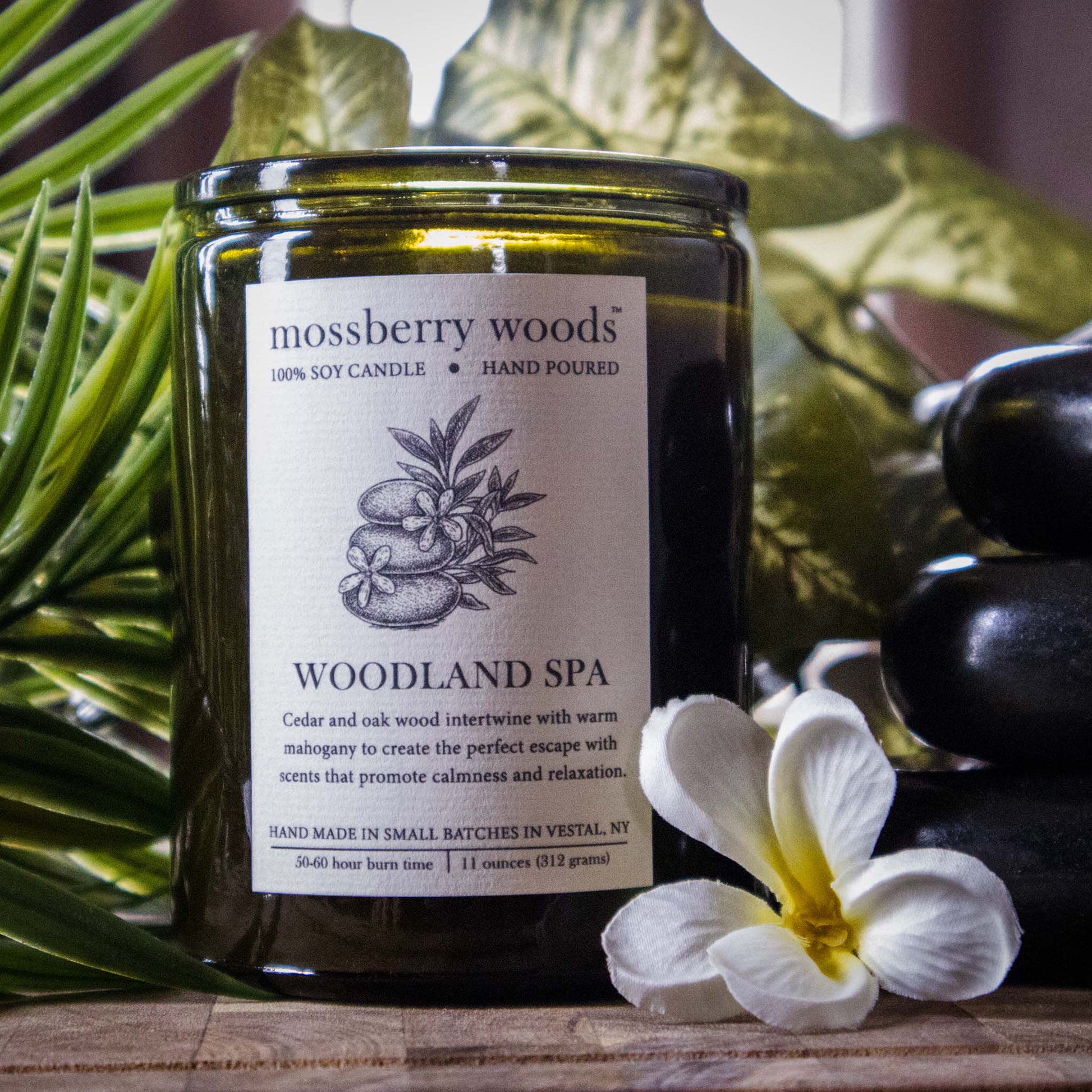 Woodland Spa Candle in front of green leaves